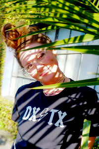 Model outside under a tree wearing the DX/TX t-shirt