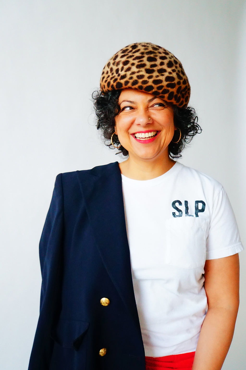 Model with leopard hat and navy coat wearing the SLP pocket t-shirt