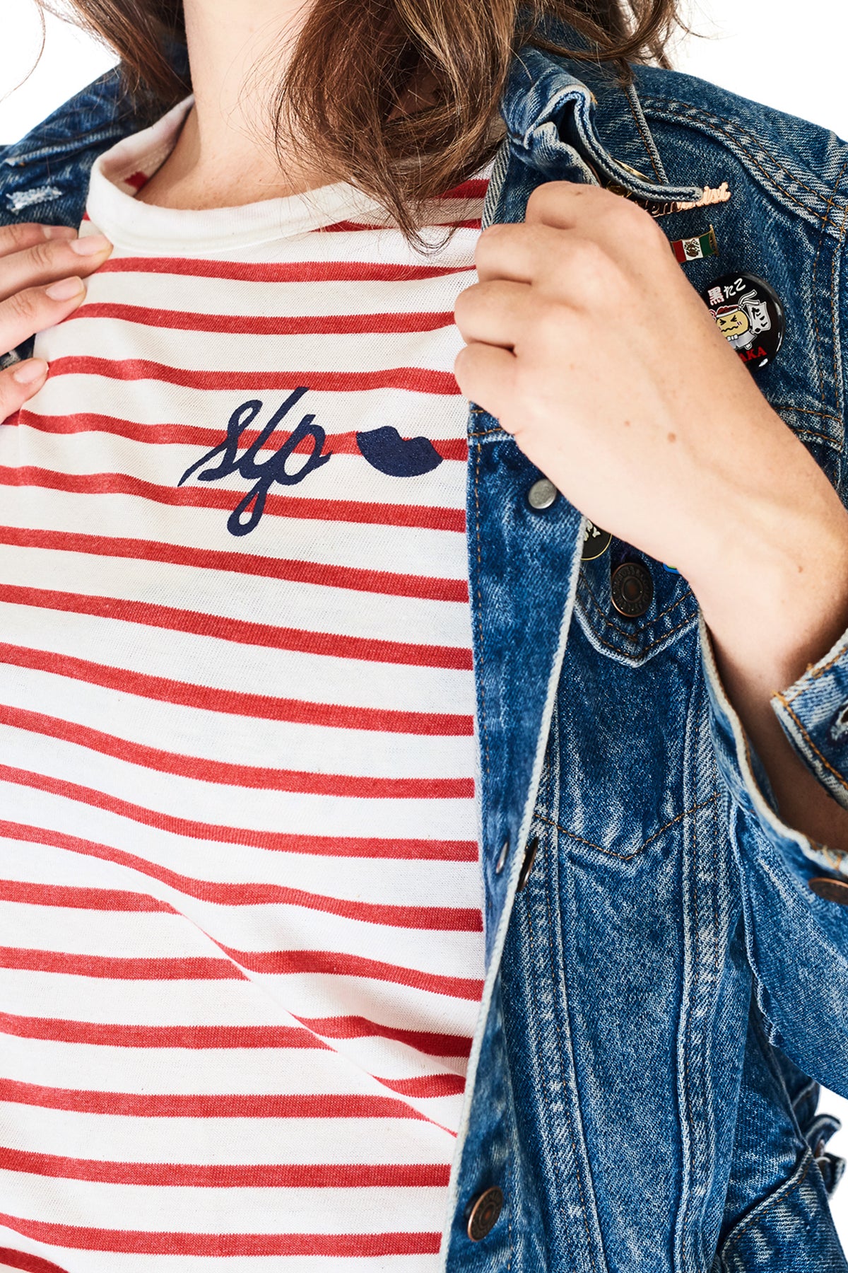 Model wearing a jean jackets with the women's slim fit The Stripes t-shirt in white and red