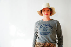 Model with a hat wearing the unisex slim fit Speech-Language Pathologist UNI sweatshirt in grey